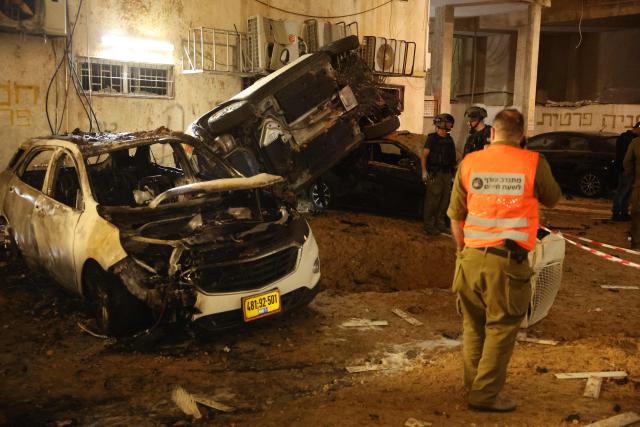 Israeli security checks the damage to cars after a rocket strike in Holon, Israel, on March 15, 2026. (Photo by Jack GUEZ / AFP) / Attention editors: Photo taken with approval from the Ministry of Culture and Islamic Guidance (Ershad) --
AFP covers the war in the Middle East through its extensive regional network, including bureaus in Tehran, Jerusalem, and several neighboring countries. Since the start of the conflict, journalists have been working under increasingly restrictive conditions. Authorities in several countries have limited reporters' movements, photo and live video coverage from sensitive locations. Some governments and armed groups have banned images of missile or drone strikes and other security-related sites. / 