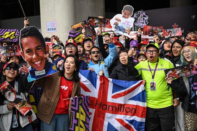 Supporters of Ferrari's British driver Lewis Hamilton pose as they arrive for the Formula One Chinese Grand Prix at the Shanghai International Circuit in Shanghai on March 15, 2026. (Photo by Jade GAO / AFP)