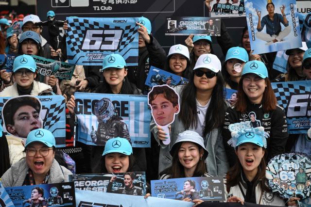 Supporters of Mercedes' British driver George Russell pose as they arrive for the Formula One Chinese Grand Prix at the Shanghai International Circuit in Shanghai on March 15, 2026. (Photo by Jade GAO / AFP)
