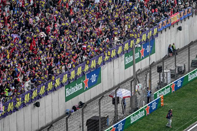 Ferrari's British driver Lewis Hamilton (bottom R) poses for photos with his supporters ahead of the Formula One Chinese Grand Prix at the Shanghai International Circuit in Shanghai on March 15, 2026. (Photo by Jade GAO / AFP)