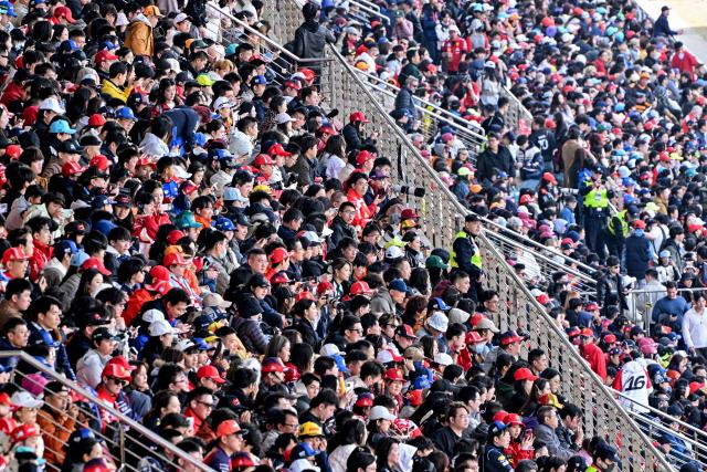 Spectators gather in the stands prior to the Formula One Chinese Grand Prix at the Shanghai International Circuit in Shanghai on March 15, 2026. (Photo by HECTOR RETAMAL / AFP)