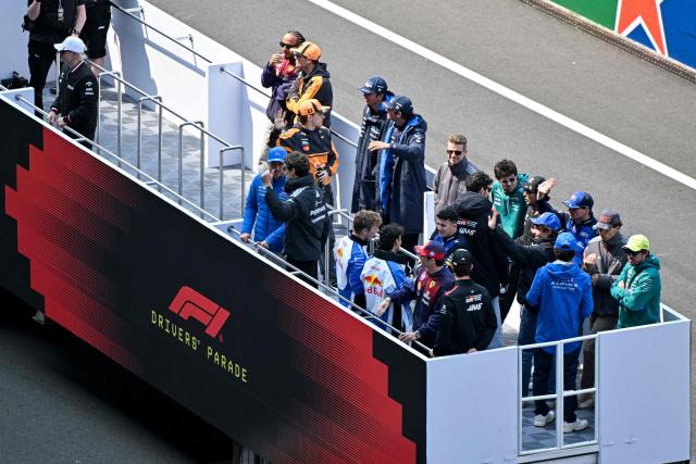 Pilots take part in the drivers' parade prior to the Formula One Chinese Grand Prix at the Shanghai International Circuit in Shanghai on March 15, 2026. (Photo by HECTOR RETAMAL / AFP)