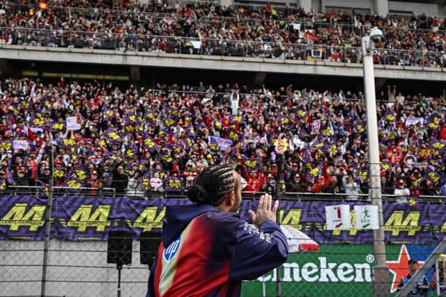 Ferrari's British driver Lewis Hamilton greets his supporters prior to the Formula One Chinese Grand Prix at the Shanghai International Circuit in Shanghai on March 15, 2026. (Photo by Greg Baker / AFP)