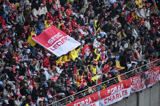 Supporters of Ferrari's Monegasque driver Charles Leclerc cheer during the drivers' parade ahead of the Formula One Chinese Grand Prix at the Shanghai International Circuit in Shanghai on March 15, 2026. (Photo by Jade GAO / AFP)