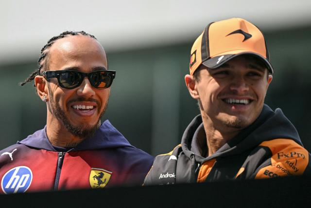 Ferrari's British driver Lewis Hamilton (L) and McLaren's British driver Lando Norris (R) look on during the drivers' parade prior to the Formula One Chinese Grand Prix at the Shanghai International Circuit in Shanghai on March 15, 2026. (Photo by Greg Baker / AFP)