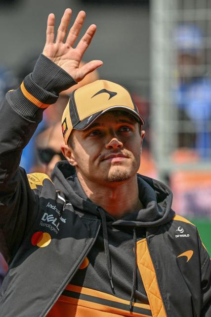 McLaren's British driver Lando Norris gestures as he arrives for the drivers' parade prior to the Formula One Chinese Grand Prix at the Shanghai International Circuit in Shanghai on March 15, 2026. (Photo by Greg Baker / AFP)