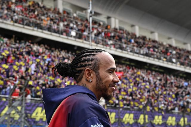 Ferrari's British driver Lewis Hamilton poses in front of his supporters prior to the Formula One Chinese Grand Prix at the Shanghai International Circuit in Shanghai on March 15, 2026. (Photo by Greg Baker / AFP)
