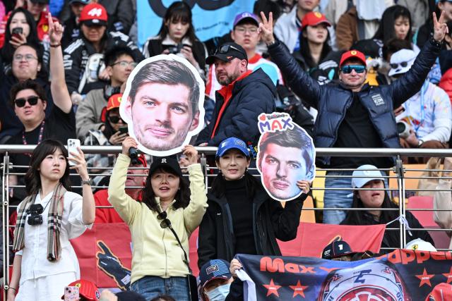 Supporters cheers with cut-outs of Red Bull Racing's Dutch driver Max Verstappen prior to the Formula One Chinese Grand Prix at the Shanghai International Circuit in Shanghai on March 15, 2026. (Photo by Greg Baker / AFP)