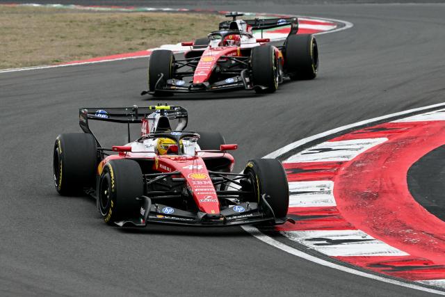 Ferrari's British driver Lewis Hamilton drives in front of Ferrari's Monegasque driver Charles Leclerc during the Formula One Chinese Grand Prix at the Shanghai International Circuit in Shanghai on March 15, 2026. (Photo by Greg Baker / AFP)
