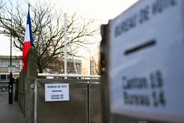 This photograph taken on March 15, 2026, shows a poster indicating the direction of a voting station during the first round of France's 2026 municipal elections in Le Havre, northeastern France. (Photo by Lou BENOIST / AFP)