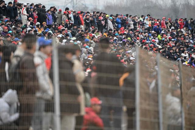 Spectators watch the Formula One Chinese Grand Prix at the Shanghai International Circuit in Shanghai on March 15, 2026. (Photo by HECTOR RETAMAL / AFP)
