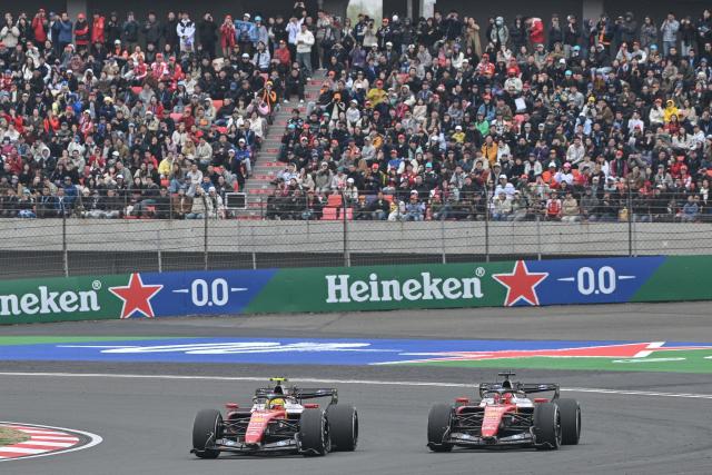 Ferrari's British driver Lewis Hamilton (L) and Ferrari's Monegasque driver Charles Leclerc (R) drive during the Formula One Chinese Grand Prix at the Shanghai International Circuit in Shanghai on March 15, 2026. (Photo by HECTOR RETAMAL / AFP)