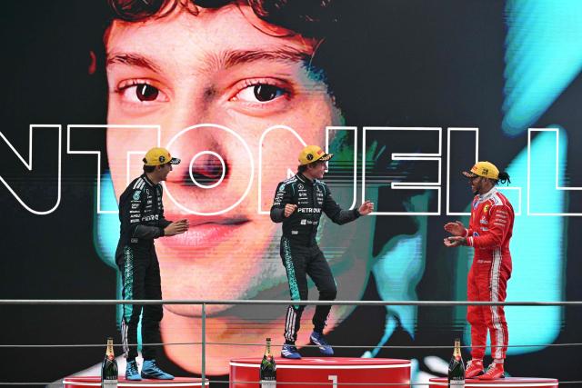 Winner Mercedes' Italian driver Kimi Antonelli (C), second-placed Mercedes' British driver George Russell (L) and third-placed Ferrari's British driver Lewis Hamilton (R) celebrate on the poidum after the Formula One Chinese Grand Prix at the Shanghai International Circuit in Shanghai on March 15, 2026. (Photo by HECTOR RETAMAL / AFP)