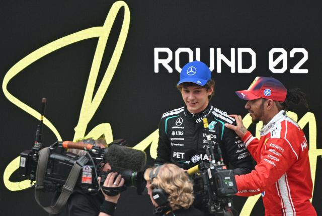 Winner Mercedes' Italian driver Kimi Antonelli (2nd R) and third-placed Ferrari's British driver Lewis Hamilton (R) speak after the Formula One Chinese Grand Prix at the Shanghai International Circuit in Shanghai on March 15, 2026. (Photo by HECTOR RETAMAL / AFP)