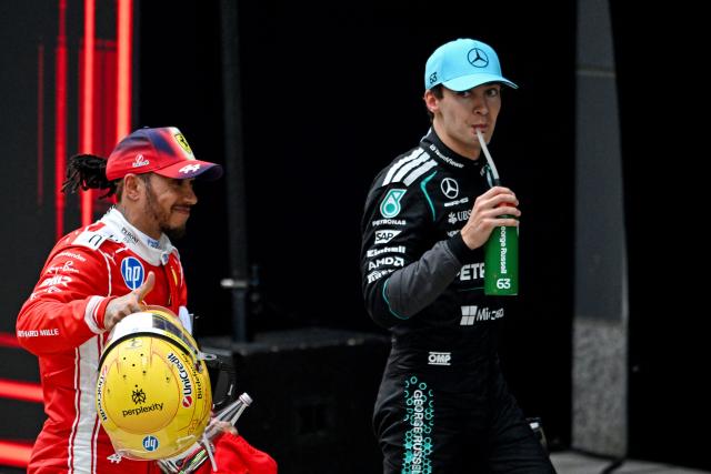 Second-placed Mercedes' British driver George Russell (R) and third-placed Ferrari's British driver Lewis Hamilton look on after the Formula One Chinese Grand Prix at the Shanghai International Circuit in Shanghai on March 15, 2026. (Photo by JADE GAO / AFP)