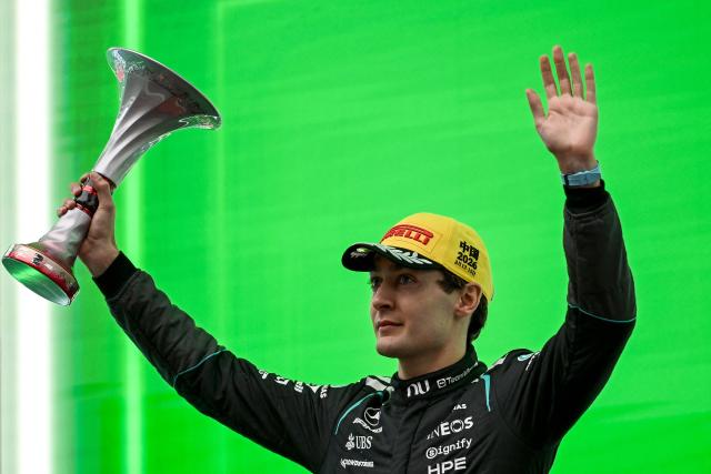 Second-placed Mercedes' British driver George Russell celebrates on the podium after the Formula One Chinese Grand Prix at the Shanghai International Circuit in Shanghai on March 15, 2026. (Photo by JADE GAO / AFP)
