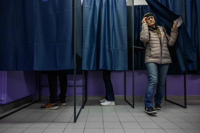 A voter exits a polling booth to cast her ballot during the first round of France's 2026 municipal elections in Perpignan, southern France, on March 15, 2026. (Photo by Ed JONES / AFP)