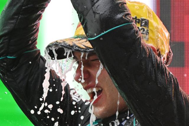 Mercedes' Italian driver Kimi Antonelli celebrates on the podium after winning the Formula One Chinese Grand Prix at the Shanghai International Circuit in Shanghai on March 15, 2026. (Photo by GREG BAKER / AFP)