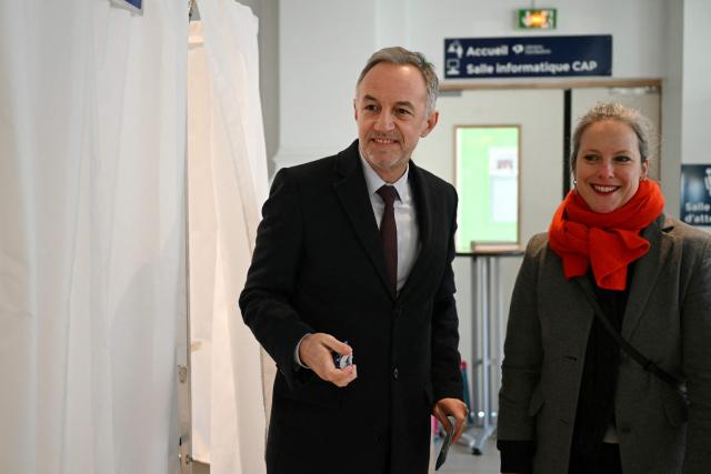 Socialist party (PS) mayoral candidate in Paris, Emmanuel Gregoire (L), next to French mayoral candidate for Paris' 12th arrondissement Lucie Castets, leaves the voting booth before casting his vote during the first round of France's 2026 municipal elections in Paris on March 15, 2026. (Photo by Bertrand GUAY / POOL / AFP)