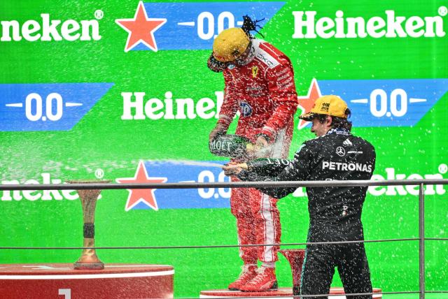 Winner Mercedes' Italian driver Kimi Antonelli (R) and third-placed Ferrari's British driver Lewis Hamilton (C) celebrate on the podium after the Formula One Chinese Grand Prix at the Shanghai International Circuit in Shanghai on March 15, 2026. (Photo by Hector RETAMAL / AFP)