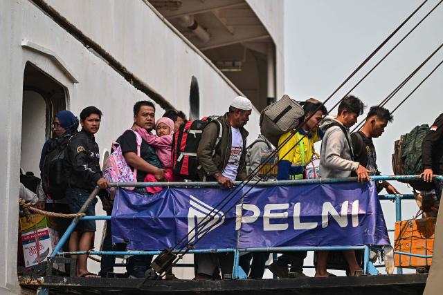 Passengers disembark from a ferry at the Perak seaport in Surabaya on March 15, 2026, as people travel to their hometowns ahead of Eid al-Fitr which marks the end of the Muslim holy fasting month of Ramadan. (Photo by JUNI KRISWANTO / AFP)