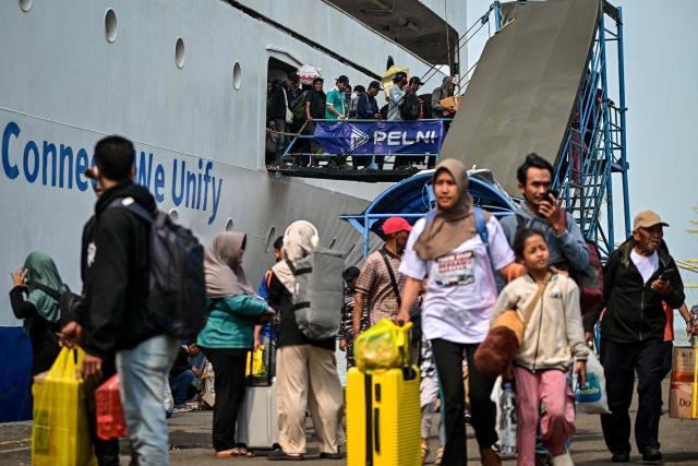 Passengers disembark from a ferry at the Perak seaport in Surabaya on March 15, 2026, as people travel to their hometowns ahead of Eid al-Fitr which marks the end of the Muslim holy fasting month of Ramadan. (Photo by JUNI KRISWANTO / AFP)