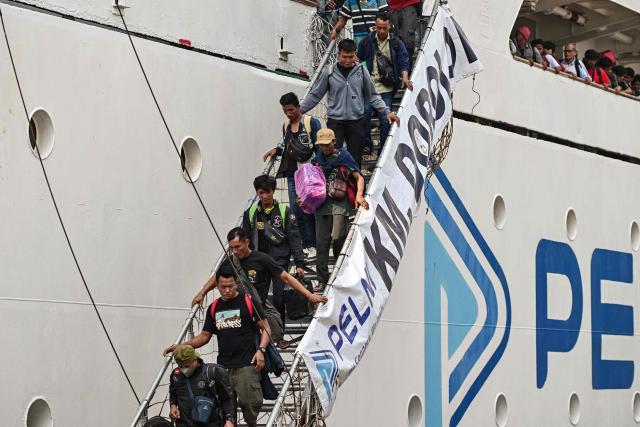 Passengers disembark from a ferry at the Perak seaport in Surabaya on March 15, 2026, as people travel to their hometowns ahead of Eid al-Fitr which marks the end of the Muslim holy fasting month of Ramadan. (Photo by JUNI KRISWANTO / AFP)
