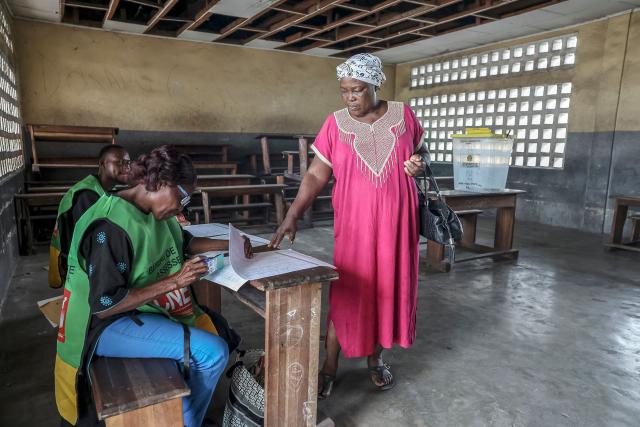 An electoral agent checks a voter's information at a polling station in Brazzaville on March 15, 2026 during the Republic of Congo's presidential elections. (Photo by Daniel BELOUMOU OLOMO / AFP)