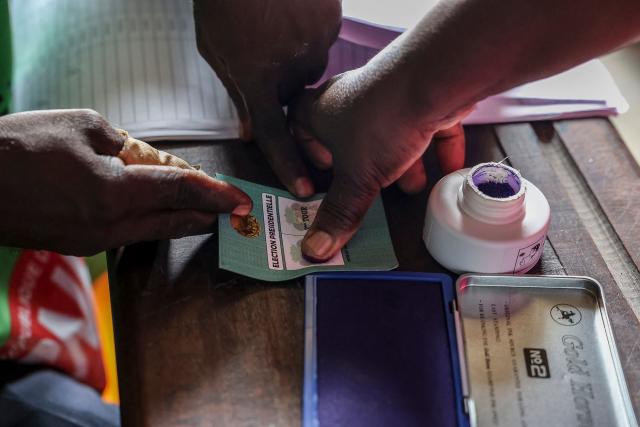 A voter marks her voting card with her fingerprint using indelible ink at a polling station in Brazzaville on March 15, 2026 during the Republic of Congo's presidential elections. (Photo by Daniel BELOUMOU OLOMO / AFP)