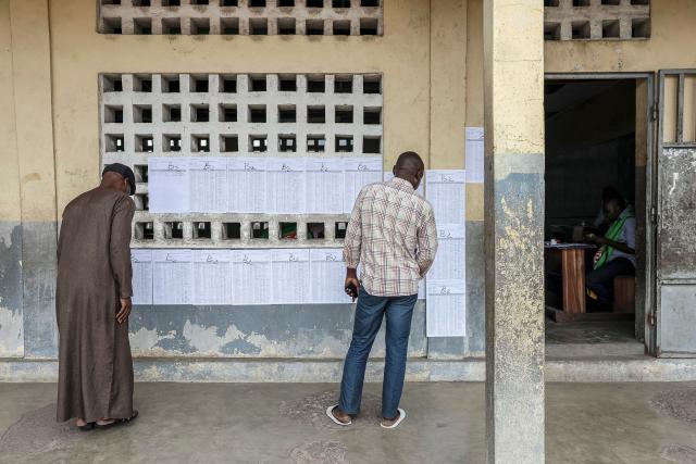 Voters look for their names on the voters' roll at a polling station in Brazzaville on March 15, 2026 during the Republic of Congo's presidential elections. (Photo by Daniel BELOUMOU OLOMO / AFP)