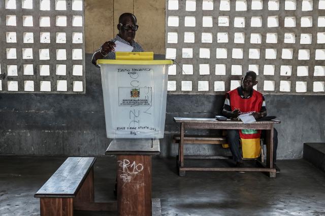 A voter (L) casts his ballot as a party agent watches at a polling station in Brazzaville on March 15, 2026 during the Republic of Congo's presidential elections. (Photo by Daniel BELOUMOU OLOMO / AFP)