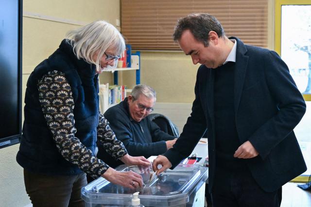 France's Prime Minister Sebastien Lecornu (R), a candidate on the broad right-wing list "Generations Vernon", casts his ballot during the first round of France's 2026 municipal elections in Vernon, northwestern France, on March 15, 2026. (Photo by Martin LELIEVRE / POOL / AFP)