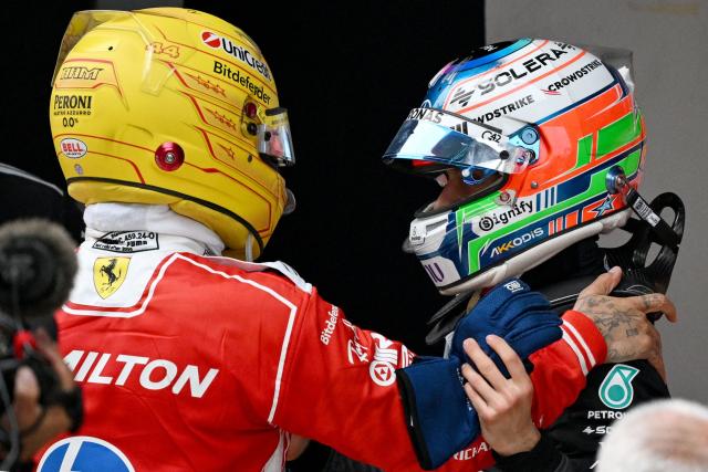Winner Mercedes' Italian driver Kimi Antonelli (R) is congratulated by third-placed Ferrari's British driver Lewis Hamilton after the Formula One Chinese Grand Prix at the Shanghai International Circuit in Shanghai on March 15, 2026. (Photo by GREG BAKER / AFP)