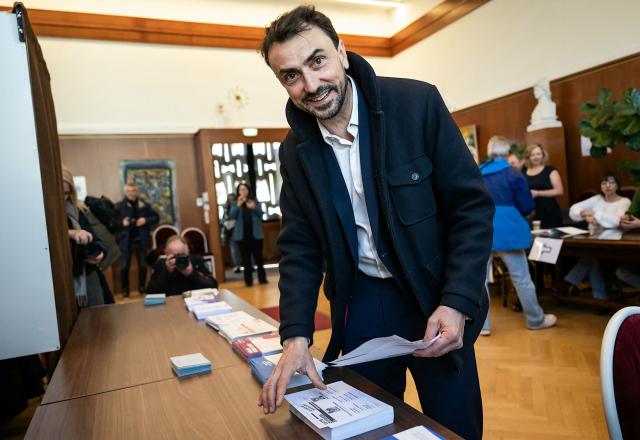Incumbent mayor of Lyon and Europe-Ecology The Greens (EELV) party candidate for re-election Gregory Doucet collects the ballot papers prior to cast his ballot during the first round of France's 2026 municipal elections in Lyon, central eastern France, on March 15, 2026. (Photo by ARNAUD FINISTRE / AFP)