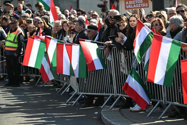 Poeple wave Hungarian national flags and hold banners as they attend a "Peace March" in support of the government of Hungary's Prime Minister on Margaret Bridge in Budapest, Hungary on March 15, 2026, to commemorate the 178th anniversary of the Hungarian Revolution and War of Independence of 1848-1849. The 1848-1849 revolution in the Kingdom of Hungary grew into a war for independence from the Austrian Empire, ruled by the Habsburg dynasty. (Photo by Attila KISBENEDEK / AFP)