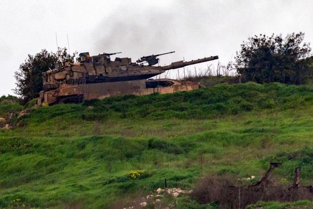 An Israeli army tank manoeuvres across the border inside Lebanon as seen from the Upper Galilee in northern Israel on March 15, 2026. Overnight strikes in southern Lebanon killed at least four people, Lebanese state media and the government said on March 15, as Israel said it was pressing its campaign against Iran-backed Hezbollah. According to Lebanon's health ministry, Israeli air strikes have killed 826 people in Lebanon since the start of the latest war, which began March 2 with Hezbollah firing missiles at Israel. (Photo by Odd ANDERSEN / AFP)