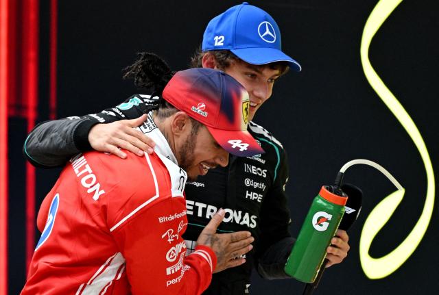 Winner Mercedes' Italian driver Kimi Antonelli (R) celebrates with third-placed Ferrari's British driver Lewis Hamilton after the Formula One Chinese Grand Prix at the Shanghai International Circuit in Shanghai on March 15, 2026. (Photo by GREG BAKER / AFP)