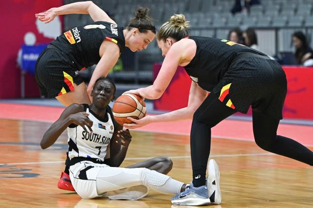 South Sudan's Nyamer Diew (C) reacts after falling on the court while challenged by Belgium´s Antonia Delaere (L) and Emma Meesseman (R) during the FIBA Women's Basketball World Cup 2026 qualifying tournament game between Belgium and South Sudan in Wuhan, in China's central Hubei province on March 15, 2026. (Photo by CN-STR / AFP) / China OUT
