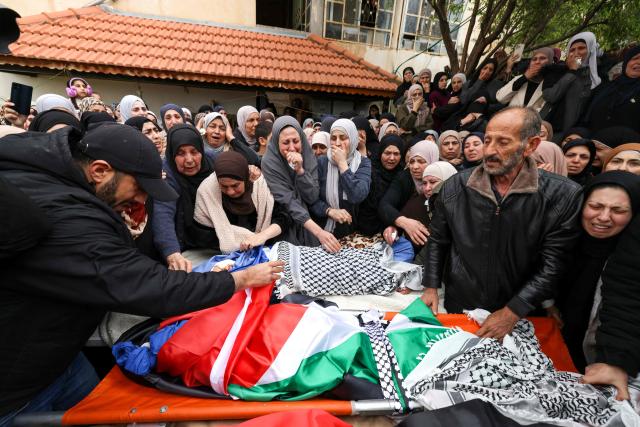 Family members grieve over the bodies of four members of a Palestinian family, including two children, killed by Israeli soldiers in their vehicle, during their funeral in the Israeli-occupied West Bank's northern town of Tammun on March 15, 2026. Israeli forces shot dead four members of a Palestinian family, a 37-year-old man, his 35-year-old wife and two boys aged five and seven, in the occupied West Bank, the Palestinian health ministry reported, while Israel said troops opened fire over a perceived safety threat. According to an AFP tally based on Palestinian health ministry figures, Israeli troops or settlers have killed at least 1,045 Palestinians -- many of them militants, but also scores of civilians -- in the West Bank since the start of the Gaza war. (Photo by JAAFAR ASHTIYEH / AFP)