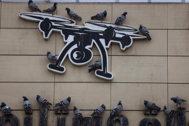 Pigeons shelter from the rain on a sign depicting a drone in the Iraqi capital Baghdad on March 15, 2026. Iraq, long a proxy battleground between the United States and Iran, was quickly dragged into the Middle East war triggered by US and Israeli strikes on Iran on February 28 . (Photo by AHMAD AL-RUBAYE / AFP)