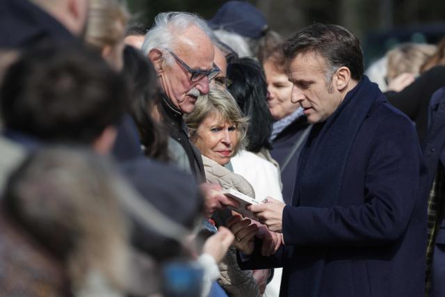 France's President Emmanuel Macron (R) speaks with inhabitatns as he arrives to vote during the first round of France's 2026 municipal elections in Le Touquet, northern France, on March 15, 2026. (Photo by Ludovic MARIN / AFP)
