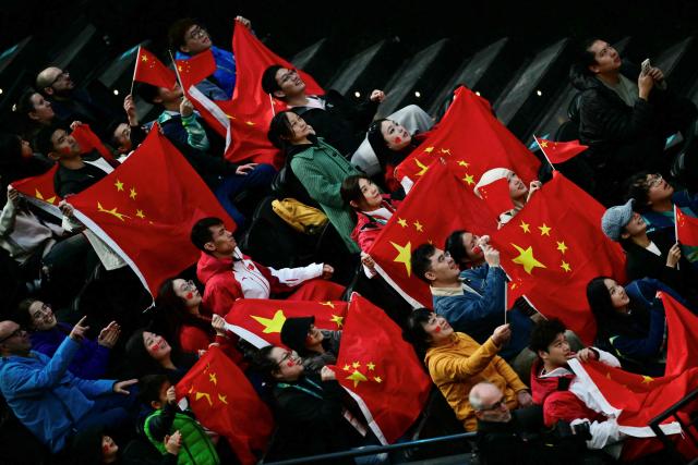 China's supporters hold flags during the ice hockey match between Czech Republic and China at the Milano Cortina 2026 Paralympic Winter Games in Milan on March 15, 2026. (Photo by Stefano RELLANDINI / AFP)