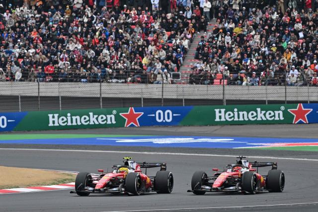 Ferrari's British driver Lewis Hamilton (L) and Ferrari's Monegasque driver Charles Leclerc (R) drive during the Formula One Chinese Grand Prix at the Shanghai International Circuit in Shanghai on March 15, 2026. (Photo by Hector RETAMAL / AFP)