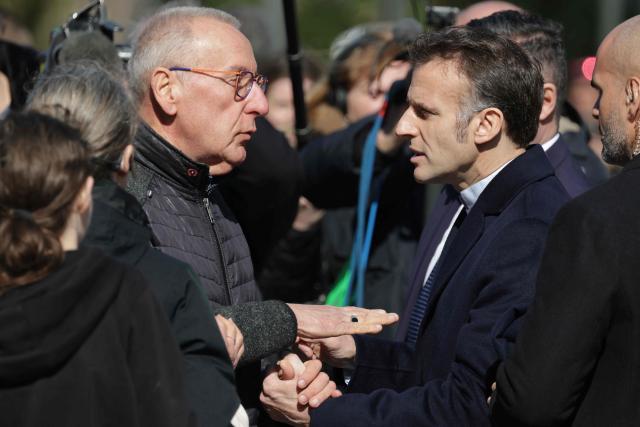 France's President Emmanuel Macron (R) speaks with inhabitants as he leaves the polling station after voting for the first round of France's 2026 municipal elections in Le Touquet, northern France, on March 15, 2026. (Photo by Ludovic MARIN / AFP)