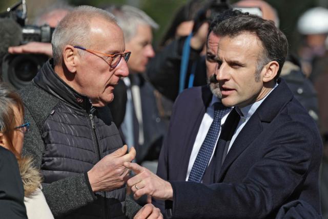 France's President Emmanuel Macron (R) speaks with inhabitants as he leaves the polling station after voting for the first round of France's 2026 municipal elections in Le Touquet, northern France, on March 15, 2026. (Photo by Ludovic MARIN / AFP)