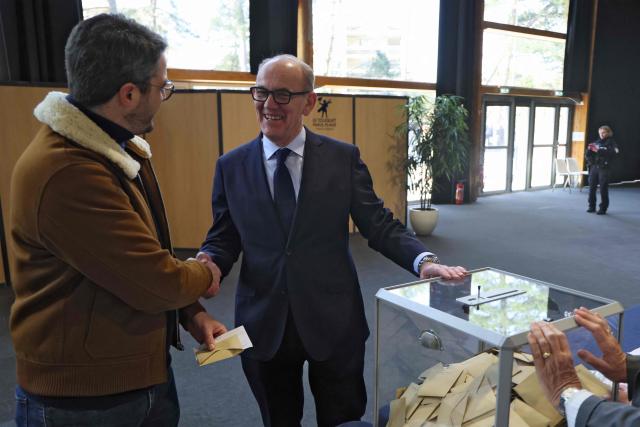 Le Touquet's mayor Daniel Fasquelle speaks with an inhabitant about to vote during the first round of France's 2026 municipal elections in Le Touquet, northern France, on March 15, 2026. (Photo by Ludovic MARIN / AFP)