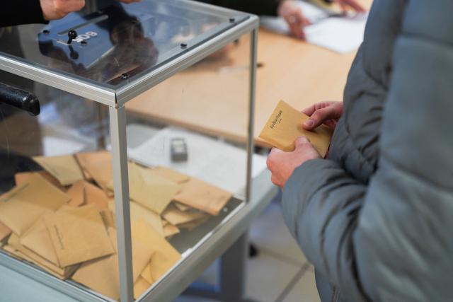 A resident holds a ballot during the first round of France's 2026 municipal elections at a polling station in Lille, northern France, on March 15, 2026. (Photo by Elise HOUBEN / AFP)