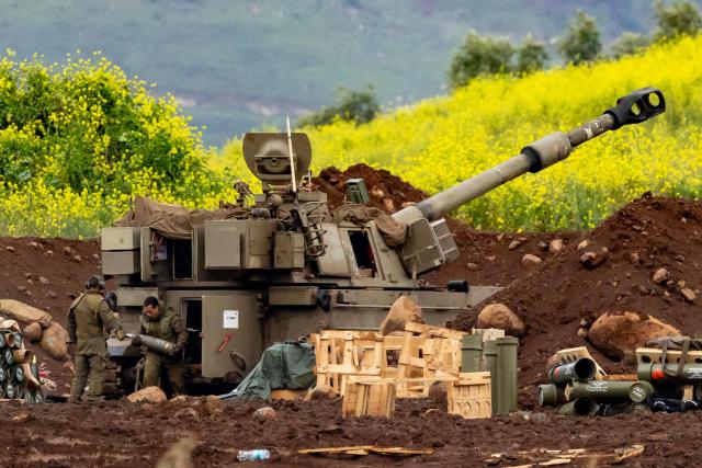 Israeli soldiers load shells into an Israeli self-propelled howitzer artillery gun firing rounds towards southern Lebanon from a position in the upper Galilee in northern Israel near the border on March 15, 2026. Israel said on March 15, 2026, that no direct talks were planned with Lebanon to end the war, a day after a Lebanese official said Beirut was preparing a delegation to negotiate with Israel. (Photo by Odd ANDERSEN / AFP) / 