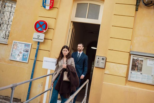 Menton's right-wing coalition "Renouveau Mentonnais" (Menton Revival) mayoral candidate, Louis Sarkozy, accompanied by his wife Natali Husic (L) leaves after voting during the first round of France's 2026 municipal elections in Menton, southeastern France on March 15, 2026. (Photo by Frederic DIDES / AFP)
