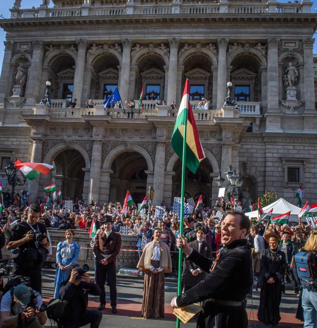 Hungarian opposition leader and president of the TISZA (Respect and Freedom) party Peter Magyar (R) raises a national flag of Hungary during a "National March” in Budapest, Hungary on March 15, 2026, on the 178th anniversary of the Hungarian Revolution and War of Independence of 1848-1849. The 1848-1849 revolution in the Kingdom of Hungary grew into a war for independence from the Austrian Empire, ruled by the Habsburg dynasty. (Photo by Ferenc ISZA / AFP)